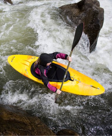 Kayaker navigating white water rapids