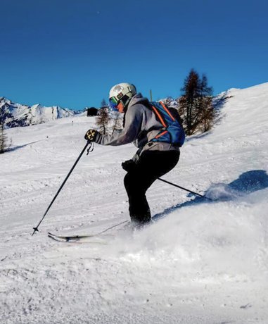 Skier gliding down a snowy slope